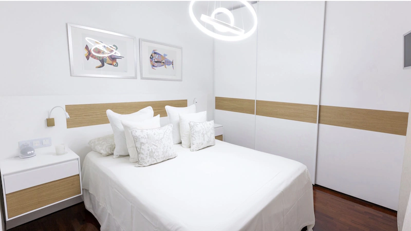 Dormitorio de matrimonio a medida en Barcelona con armario de puertas correderas, cabecero y mesitas en blanco y roble diseñado por Fustaire